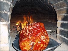 Der Beinschinken wird langsam im Offenen Feuer gebacken.